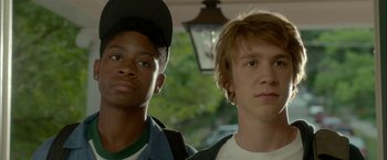 Movie still from “Me and Earl and the Dying Girl” (2015), directed by Alfonso Gomez-Rejon – Two young men standing next to each other in front of trees; Close Up shot, Low angle