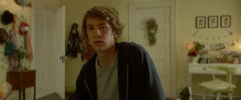Movie still from “Me and Earl and the Dying Girl” (2015), directed by Alfonso Gomez-Rejon – A young man is standing in front of a door; Close Up shot, Low angle