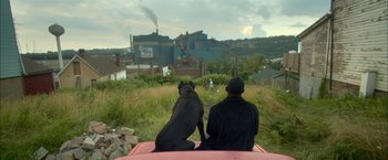 Movie still from “Me and Earl and the Dying Girl” (2015), directed by Alfonso Gomez-Rejon – A man and a dog sitting on the back of a truck; Wide shot, High angle