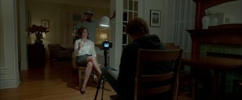 Movie still from “Me and Earl and the Dying Girl” (2015), directed by Alfonso Gomez-Rejon – A man and a woman sitting in a chair in front of a video camera; Medium shot, Over the shoulder angle