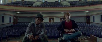 Movie still from “Me and Earl and the Dying Girl” (2015), directed by Alfonso Gomez-Rejon – Two young men sitting in front of an empty auditorium; Medium shot, Low angle