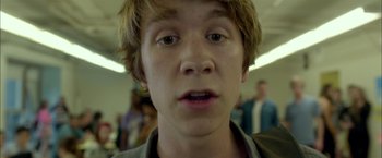 Movie still from “Me and Earl and the Dying Girl” (2015), directed by Alfonso Gomez-Rejon – A young man's face in front of a group of people; Close Up shot, Low angle