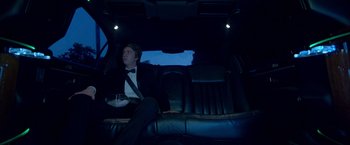 Movie still from “Me and Earl and the Dying Girl” (2015), directed by Alfonso Gomez-Rejon – A man sitting in the back seat of a limo; Medium shot, Low angle