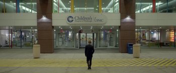 Movie still from “Me and Earl and the Dying Girl” (2015), directed by Alfonso Gomez-Rejon – A person standing in front of the entrance to a children's hospital of pittsburgh; Extreme Wide shot, Low angle