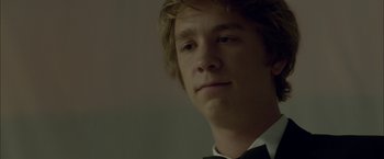 Movie still from “Me and Earl and the Dying Girl” (2015), directed by Alfonso Gomez-Rejon – A young man in a bow tie looking at the camera; Close Up shot, Over the shoulder angle