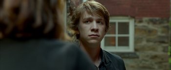 Movie still from “Me and Earl and the Dying Girl” (2015), directed by Alfonso Gomez-Rejon – A young man is standing in front of a woman; Close Up shot, Over the shoulder angle