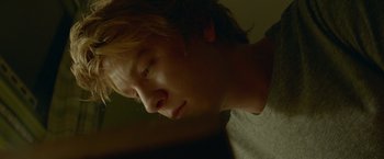 Movie still from “Me and Earl and the Dying Girl” (2015), directed by Alfonso Gomez-Rejon – A young man with long blonde hair is looking down; Close Up shot, Low angle