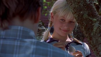 Movie still from “Mean Creek” (2004), directed by Jacob Estes – A young blonde girl is smiling for the camera; Close Up shot, Over the shoulder angle