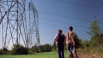 Movie still from “Mean Creek” (2004), directed by Jacob Estes – Two people walking in a field near power lines; Wide shot, Low angle