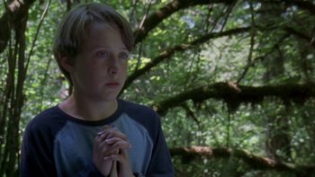 Movie still from “Mean Creek” (2004), directed by Jacob Estes – A young boy is praying in the woods; Close Up shot, High angle