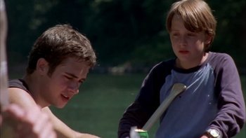 Movie still from “Mean Creek” (2004), directed by Jacob Estes – Two young boys are playing baseball in a field; Medium shot, Over the shoulder angle