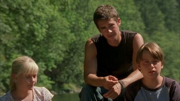 Movie still from “Mean Creek” (2004), directed by Jacob Estes – A man sitting next to another man on the ground; Medium shot, Over the shoulder angle