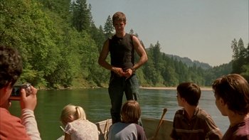 Movie still from “Mean Creek” (2004), directed by Jacob Estes – A man standing on the back of a boat in the water; Medium shot, Low angle
