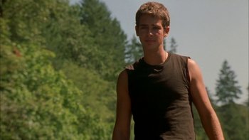 Movie still from “Mean Creek” (2004), directed by Jacob Estes – A young man standing in front of a forest; Medium shot, Over the shoulder angle