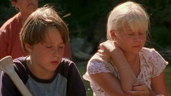 Movie still from “Mean Creek” (2004), directed by Jacob Estes – Two young children sitting next to each other in a yard; Close Up shot, Low angle