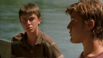 Movie still from “Mean Creek” (2004), directed by Jacob Estes – Two young men are standing next to a body of water; Close Up shot, Over the shoulder angle