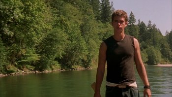 Movie still from “Mean Creek” (2004), directed by Jacob Estes – A man standing next to a body of water; Medium shot, Low angle
