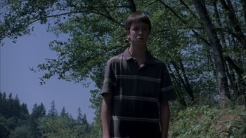 Movie still from “Mean Creek” (2004), directed by Jacob Estes – A young man standing in front of a tree; Medium shot, Low angle