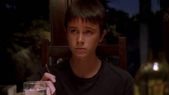 Movie still from “Mean Creek” (2004), directed by Jacob Estes – A young man sitting in a chair holding a glass of water; Close Up shot, High angle