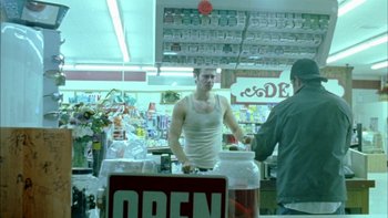 Movie still from “Mean Creek” (2004), directed by Jacob Estes – A man standing in front of an open sign in a store; Medium shot, Low angle