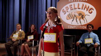 Movie still from “Mean Girls” (2004), directed by Mark Waters – A young girl standing in front of a microphone; Medium shot, Low angle