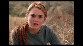 Movie still from “Mean Girls” (2004), directed by Mark Waters – A woman with long red hair sitting in a field; Close Up shot, Over the shoulder angle