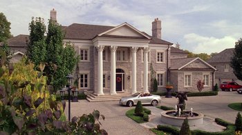 Movie still from “Mean Girls” (2004), directed by Mark Waters – A white sports car parked in front of a large mansion; Extreme Wide shot, High angle