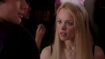 Movie still from “Mean Girls” (2004), directed by Mark Waters – A woman with long blonde hair wearing a white feather headband; Close Up shot, Over the shoulder angle