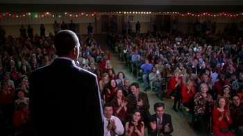 Movie still from “Mean Girls” (2004), directed by Mark Waters – A man standing in front of a crowd of people clapping and applauding; Wide shot, High angle
