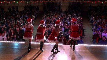 Movie still from “Mean Girls” (2004), directed by Mark Waters – A group of women dressed as santa claus performing a dance; Extreme Wide shot, High angle