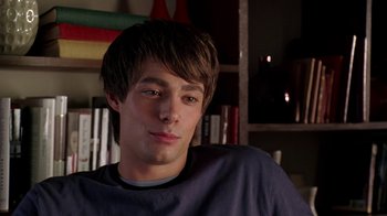 Movie still from “Mean Girls” (2004), directed by Mark Waters – A young man sitting in front of a book shelf; Close Up shot, Over the shoulder angle