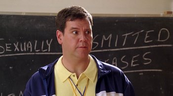 Movie still from “Mean Girls” (2004), directed by Mark Waters – A man in a yellow and blue shirt is standing in front of a chalkboard; Close Up shot, High angle