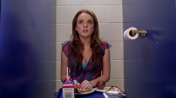 Movie still from “Mean Girls” (2004), directed by Mark Waters – A woman sitting at a table with a plate of food in front of her; Medium shot, Overhead angle