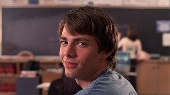 Movie still from “Mean Girls” (2004), directed by Mark Waters – A young man with brown hair is smiling for the camera; Close Up shot, Low angle
