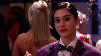 Movie still from “Mean Girls” (2004), directed by Mark Waters – A woman in a purple jacket and a bow tie; Close Up shot, Over the shoulder angle
