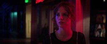 Movie still from “Fear Street: Part One - 1994” (2021), directed by Leigh Janiak – A woman with red hair and a black shirt is in a dark room; Close Up shot, Low angle