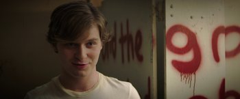 Movie still from “Fear Street: Part One - 1994” (2021), directed by Leigh Janiak – A young man in front of a wall with graffiti; Close Up shot, Over the shoulder angle