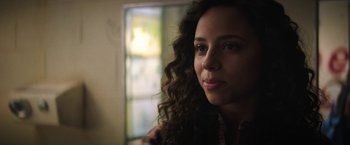 Movie still from “Fear Street: Part One - 1994” (2021), directed by Leigh Janiak – A person with curly hair; Close Up shot, Over the shoulder angle