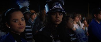 Movie still from “Fear Street: Part One - 1994” (2021), directed by Leigh Janiak – A woman wearing a helmet in a crowd of people; Close Up shot, Over the shoulder angle