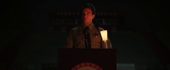 Movie still from “Fear Street: Part One - 1994” (2021), directed by Leigh Janiak – A police officer is speaking at a public event; Medium shot, Low angle