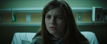 Movie still from “Fear Street: Part One - 1994” (2021), directed by Leigh Janiak – A young woman with long brown hair stares at the camera; Close Up shot, Low angle