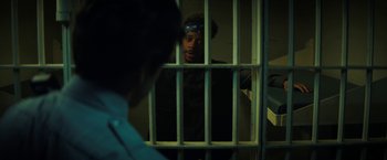 Movie still from “Fear Street: Part One - 1994” (2021), directed by Leigh Janiak – A man standing behind bars in a jail cell; Medium shot, Over the shoulder angle