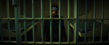 Movie still from “Fear Street: Part One - 1994” (2021), directed by Leigh Janiak – A man standing behind bars in a jail cell; Medium shot, Low angle