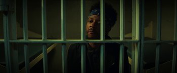 Movie still from “Fear Street: Part One - 1994” (2021), directed by Leigh Janiak – A man with a bandanna on his head is behind bars; Close Up shot, Low angle