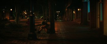 Movie still from “Fear Street: Part One - 1994” (2021), directed by Leigh Janiak – A person sitting on the ground in the dark; Wide shot, High angle