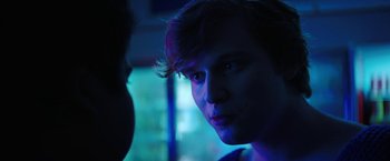 Movie still from “Fear Street: Part One - 1994” (2021), directed by Leigh Janiak – A young man stares into the distance in a dark room; Close Up shot, Over the shoulder angle