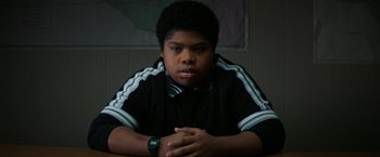 Movie still from “Fear Street: Part One - 1994” (2021), directed by Leigh Janiak – A young man sitting at a table with his hands crossed; Close Up shot, High angle