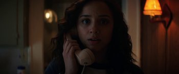Movie still from “Fear Street: Part One - 1994” (2021), directed by Leigh Janiak – A woman holding a phone up to her ear; Close Up shot, Low angle