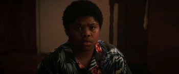 Movie still from “Fear Street: Part One - 1994” (2021), directed by Leigh Janiak – A young man in a hawaiian shirt is looking at the camera; Close Up shot, High angle