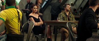 Movie still from “Mechanic: Resurrection” (2016), directed by Dennis Gansel – A woman sitting at a table next to a man; Medium shot, Over the shoulder angle